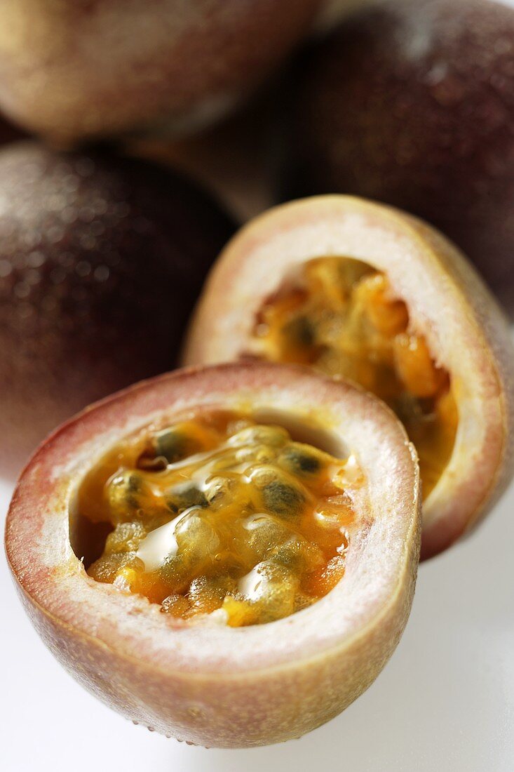 Passionsfrüchte, eine davon halbiert (Purpurgranadilla)