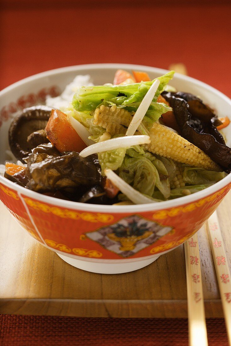 Vegetables and mushrooms cooked in wok on rice (China)