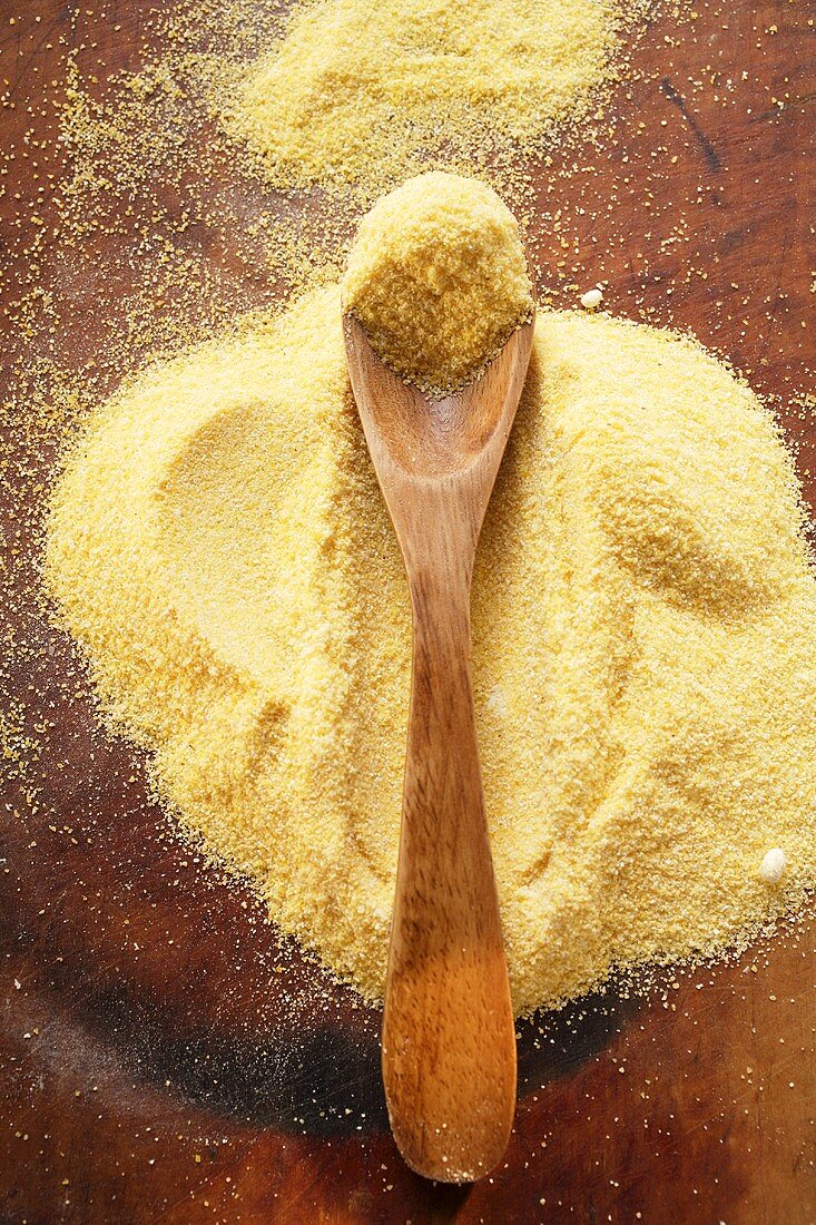 Polenta mit Holzlöffel auf Holzuntergrund