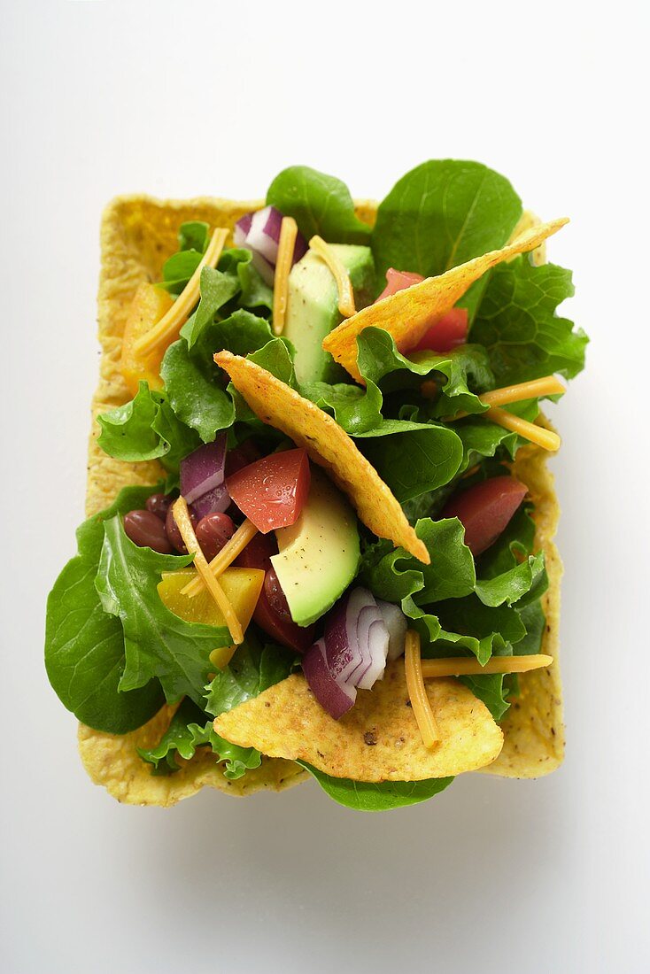 Mexikanischer Salat mit Gemüse und Tacochips in Taco-Shell