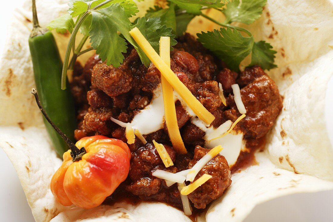 Chili con carne with cheese and sour cream in tortilla shell