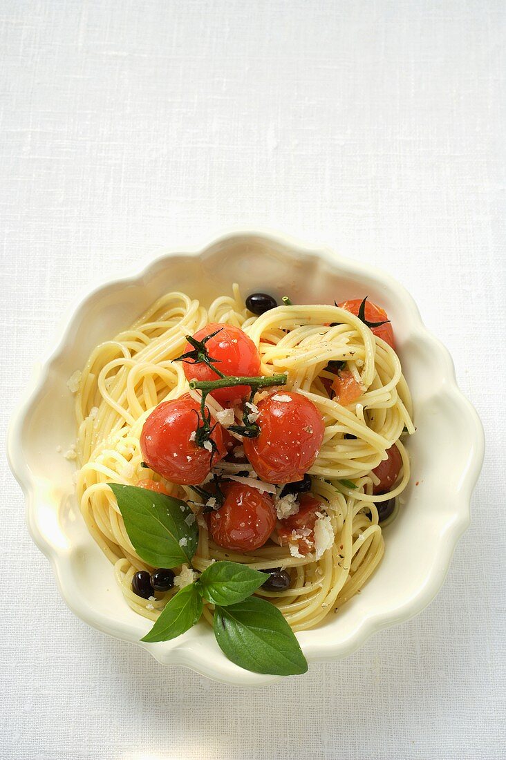 Spaghetti with cherry tomatoes, olives, cheese and basil