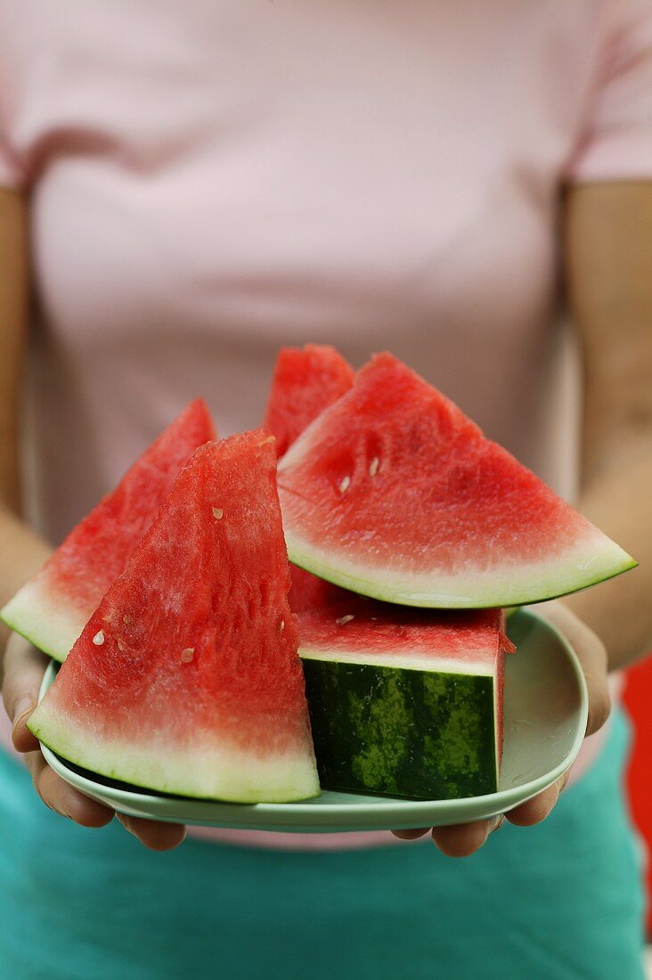 Woman holding bowl of watermelon wedges