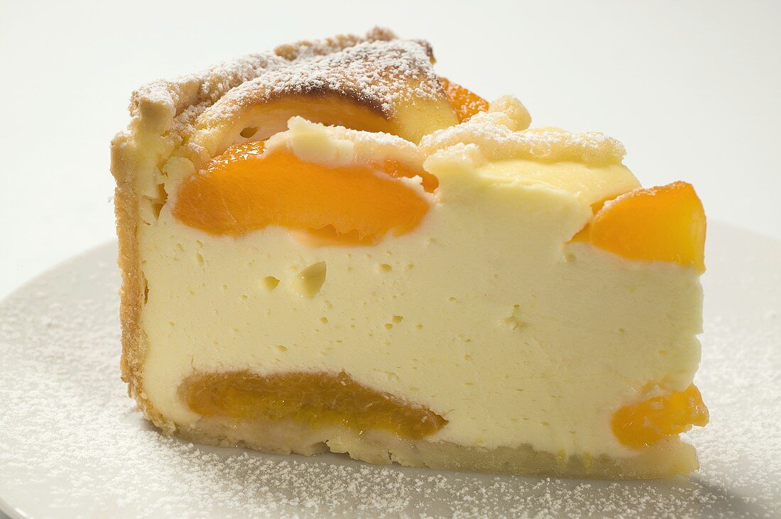 Piece of apricot cheesecake with icing sugar