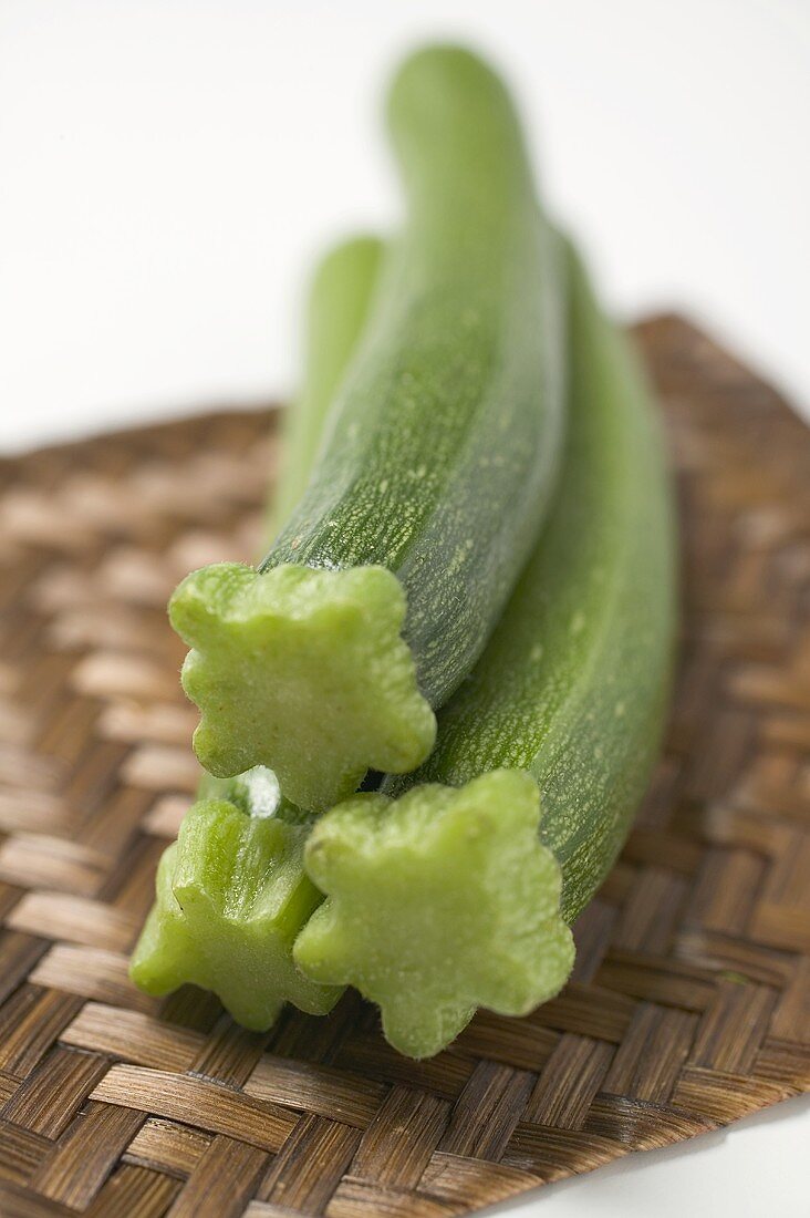 Three courgettes on bamboo mat