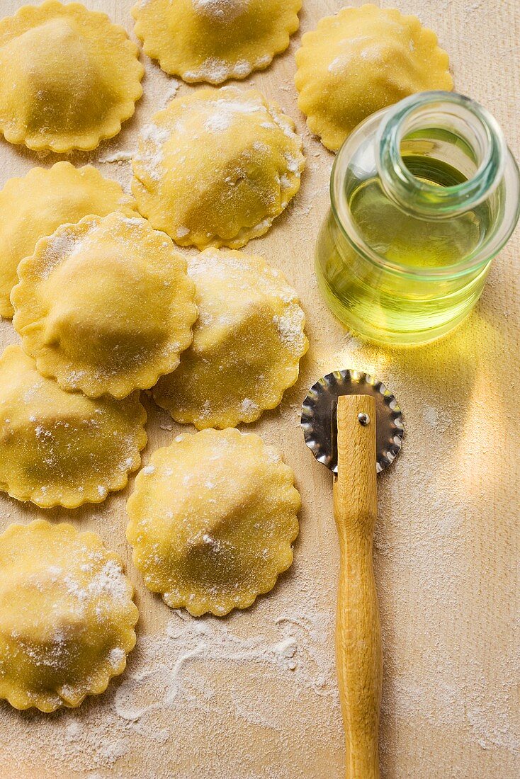 Home-made ravioli with pastry wheel and olive oil