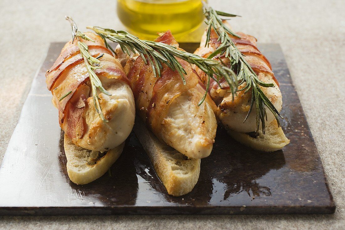 Chicken breast wrapped in bacon with rosemary on white bread