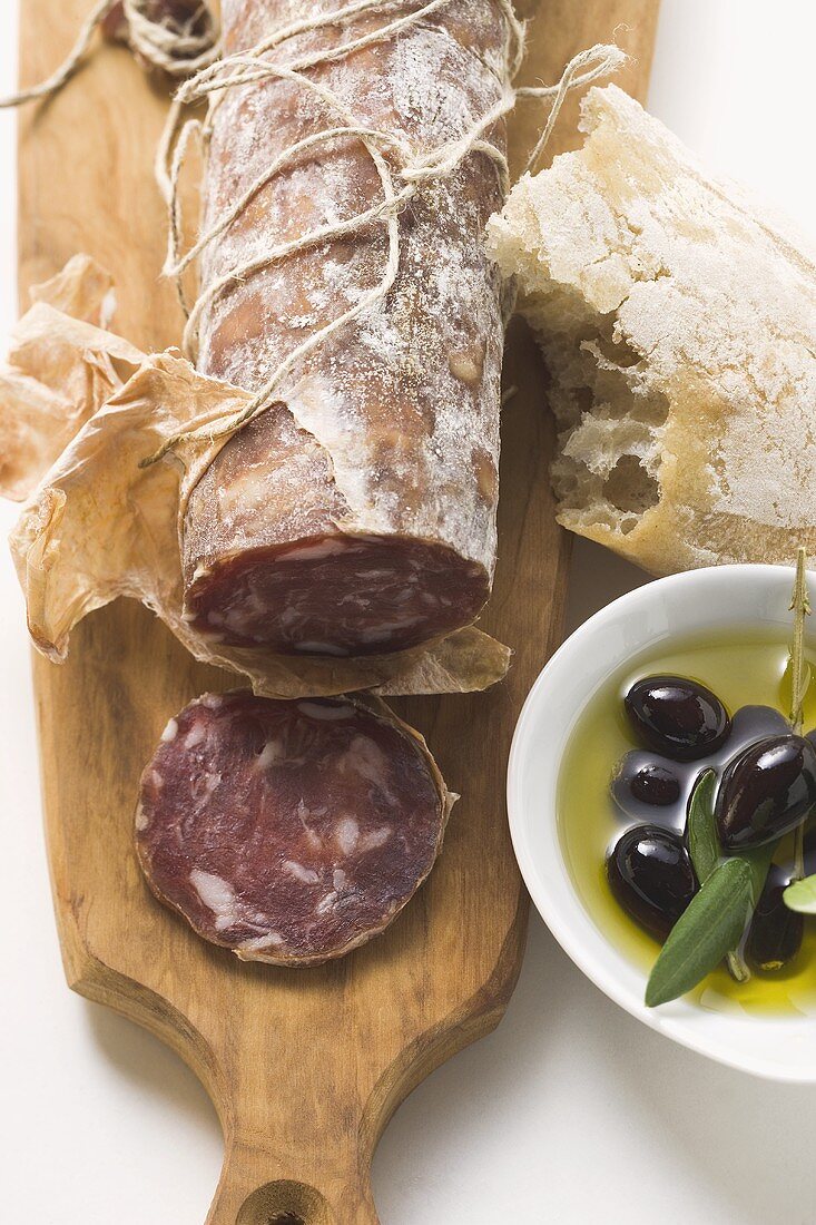 Italienische Salami, Oliven in Olivenöl, Weißbrot