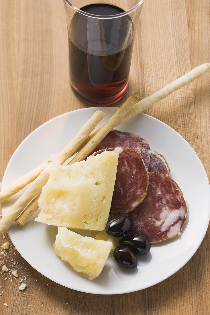 Salami, Käse, Oliven und Grissini auf Teller