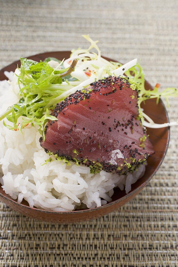 Raw tuna fillet with poppy seeds on rice