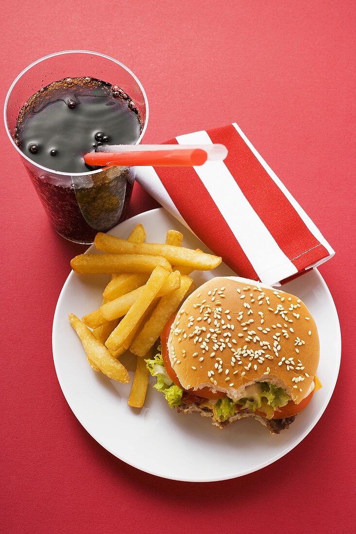 Cheeseburger, angebissen, mit Pommes frites und Cola