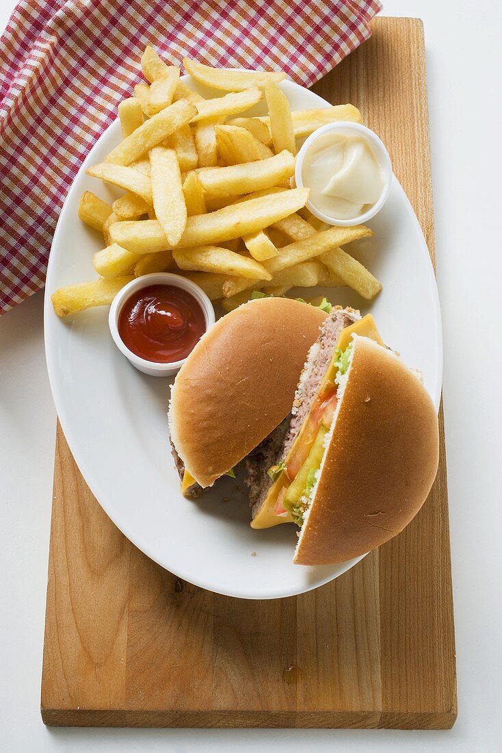 Cheeseburger, chips, mayonnaise, ketchup on plate