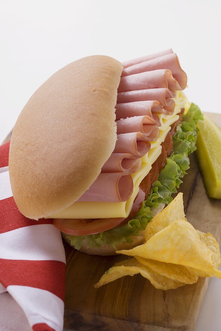 Sub-Sandwich mit Chips und Gewürzgurke auf Schneidebrett