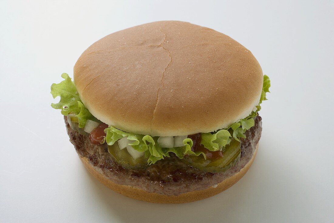 Hamburger mit Gewürzgurke, Salat, Zwiebeln und Ketchup