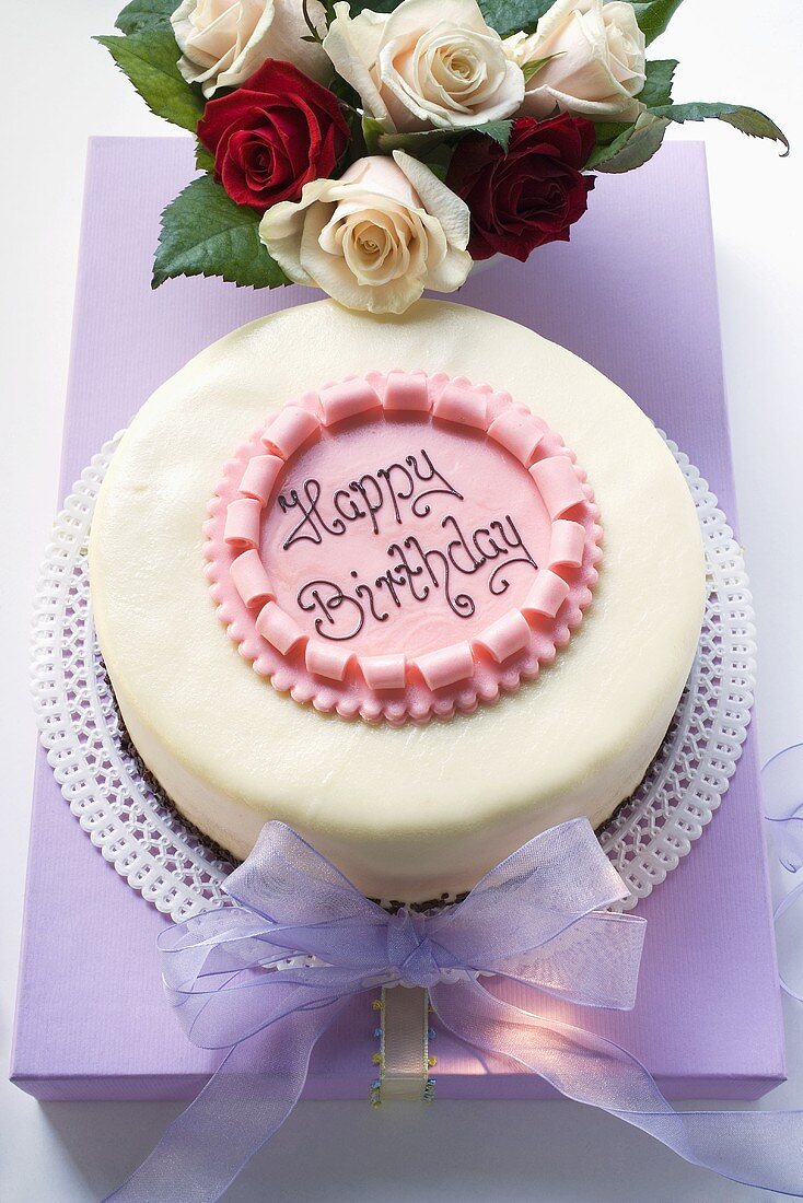 Birthday cake on pale purple box, roses