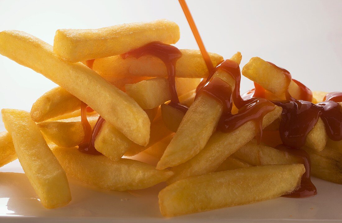 Pommes frites mit Ketchup begiessen
