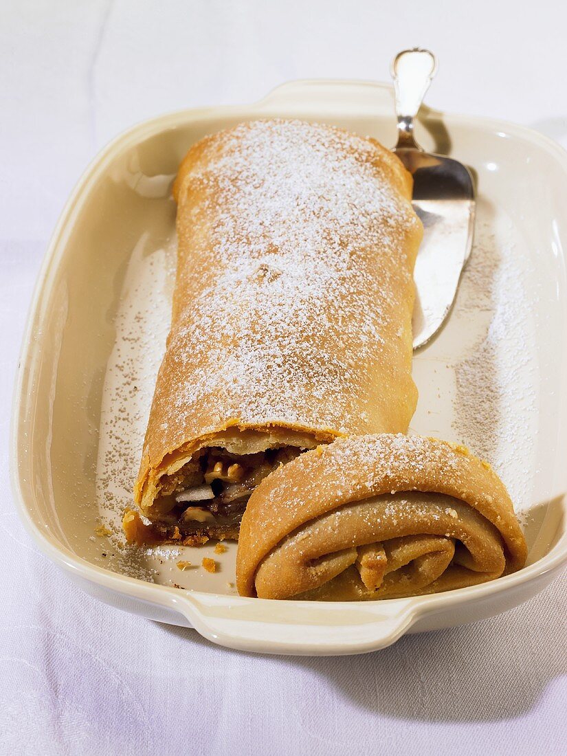 Fruit strudel with nuts and icing sugar, partly sliced