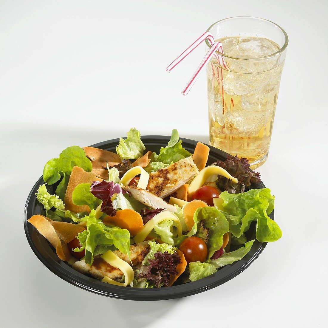 Green salad with chicken breast & vegetables, glass of lemonade