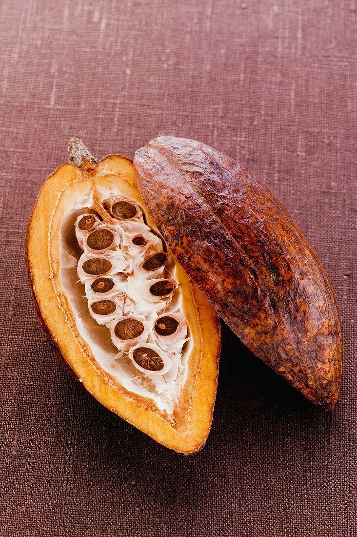 Kakaofrucht, halbiert, auf braunem Untergrund