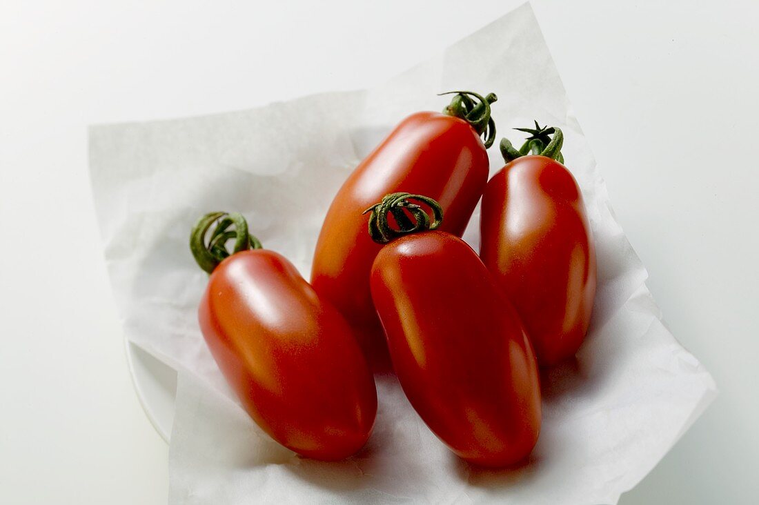 Four grape tomatoes on paper