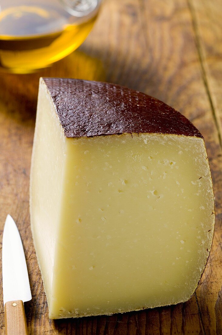 Piece of Pecorino on wooden background, olive oil