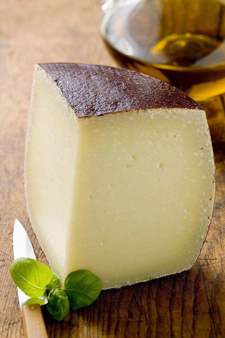 Piece of Pecorino on wooden background, olive oil