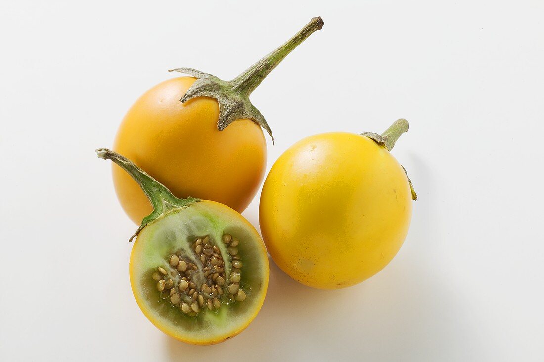 Yellow baby aubergines, whole and halved