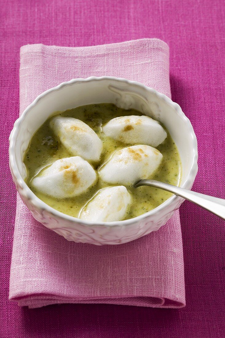 Poached meringues with pistachio sauce