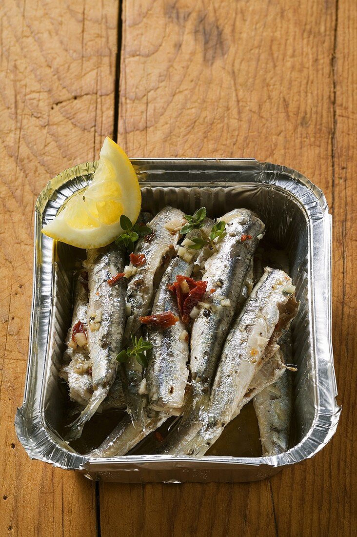 Fried anchovies with dried tomatoes in aluminium dish