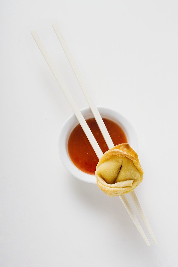 One deep-fried wonton with sweet and sour sauce