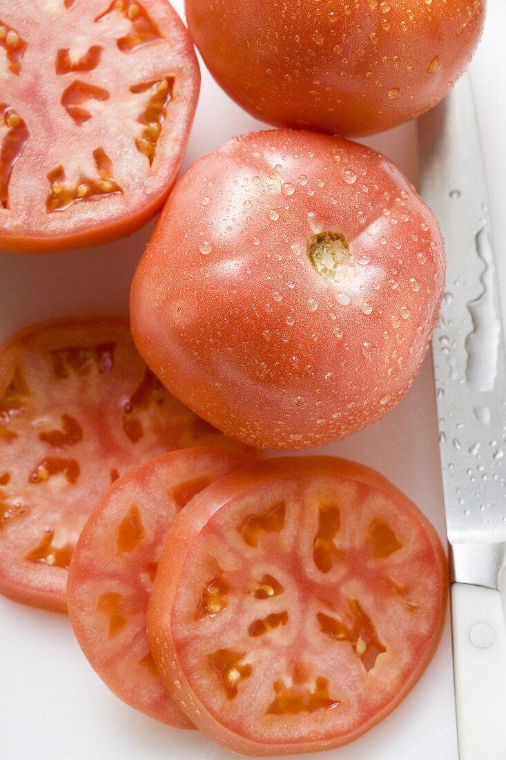 Tomatoes, whole, halved and slices, with drops of water