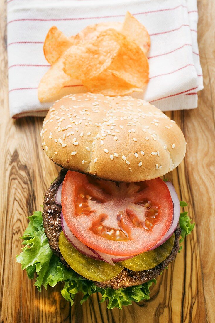 Selbstgemachter Hamburger mit Essiggurken, Zwiebeln, Tomate