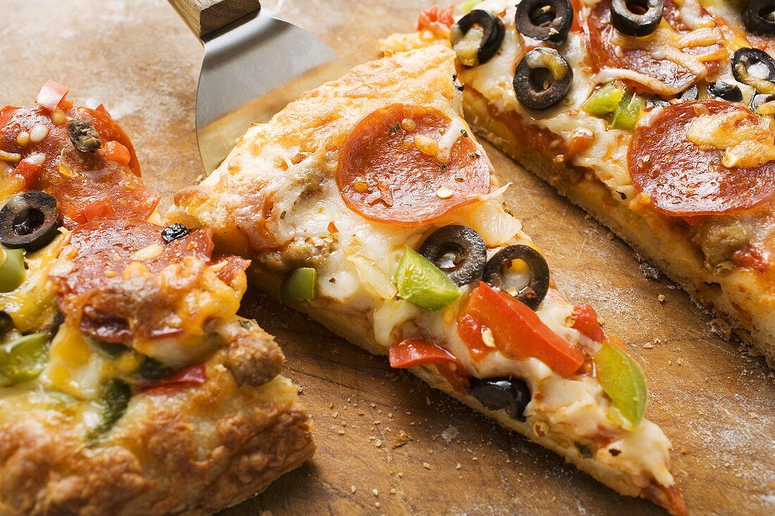 Pizza mit Peperoniwurst, Paprika und Oliven
