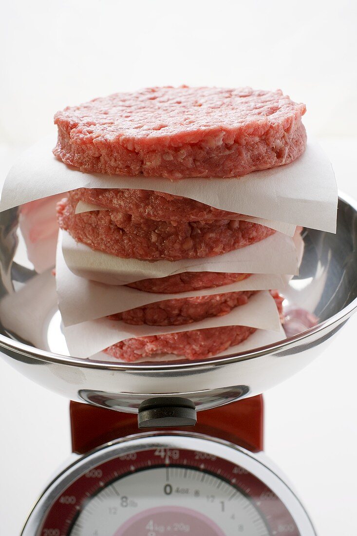 Pile of raw burgers for hamburgers on kitchen scales