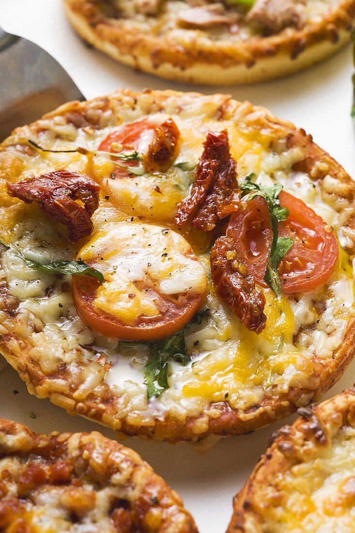 Minipizza mit frischen und getrockneten Tomaten