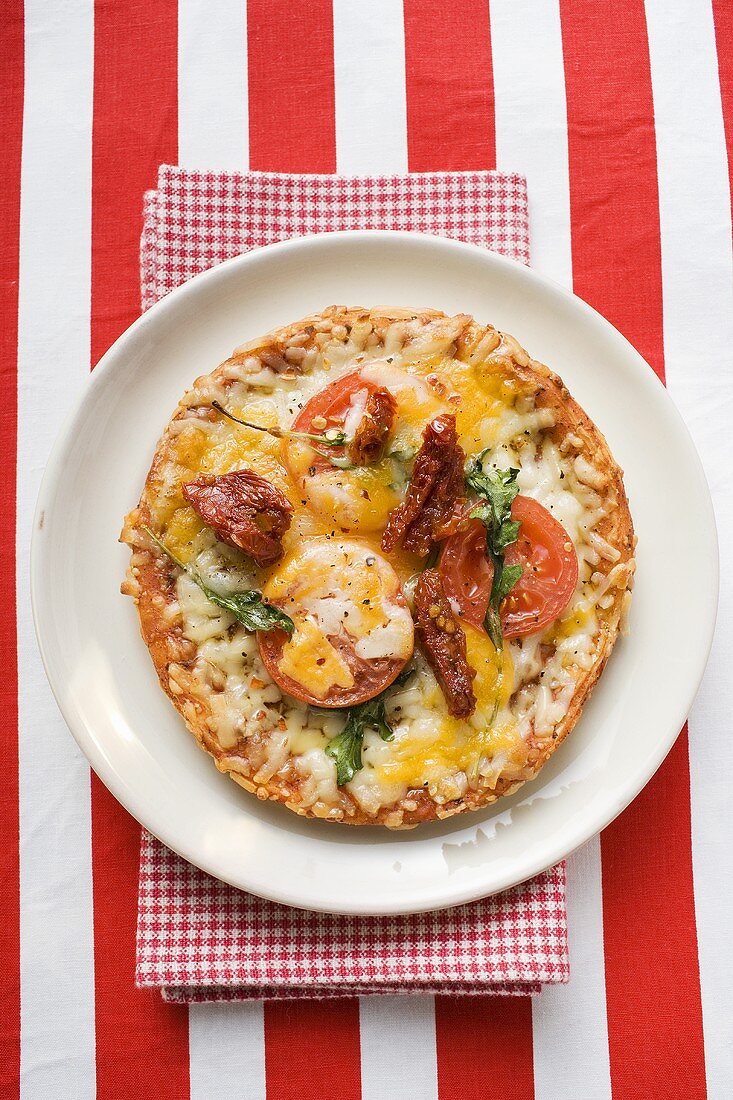 Minipizza mit frischen und getrockneten Tomaten