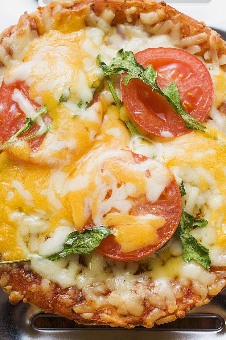 Mini-pizza with tomato, cheese and rocket
