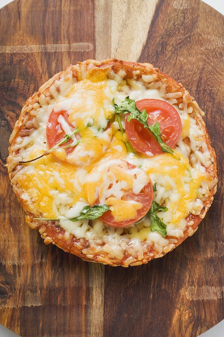 Mini-pizza with tomato, cheese and rocket