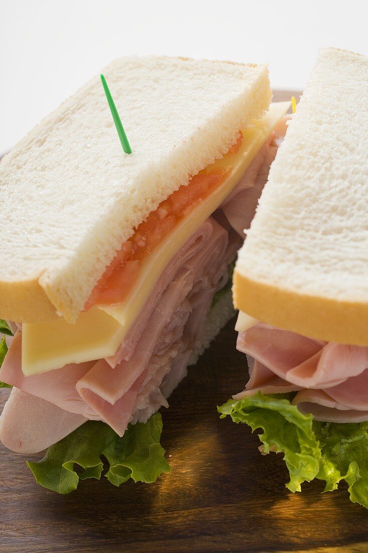 Sandwich mit Schinken, Käse und Tomaten (halbiert)
