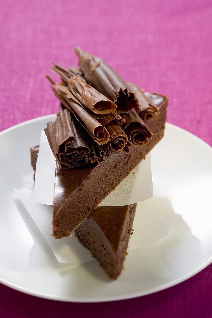 Two pieces of chocolate cake with chocolate curls