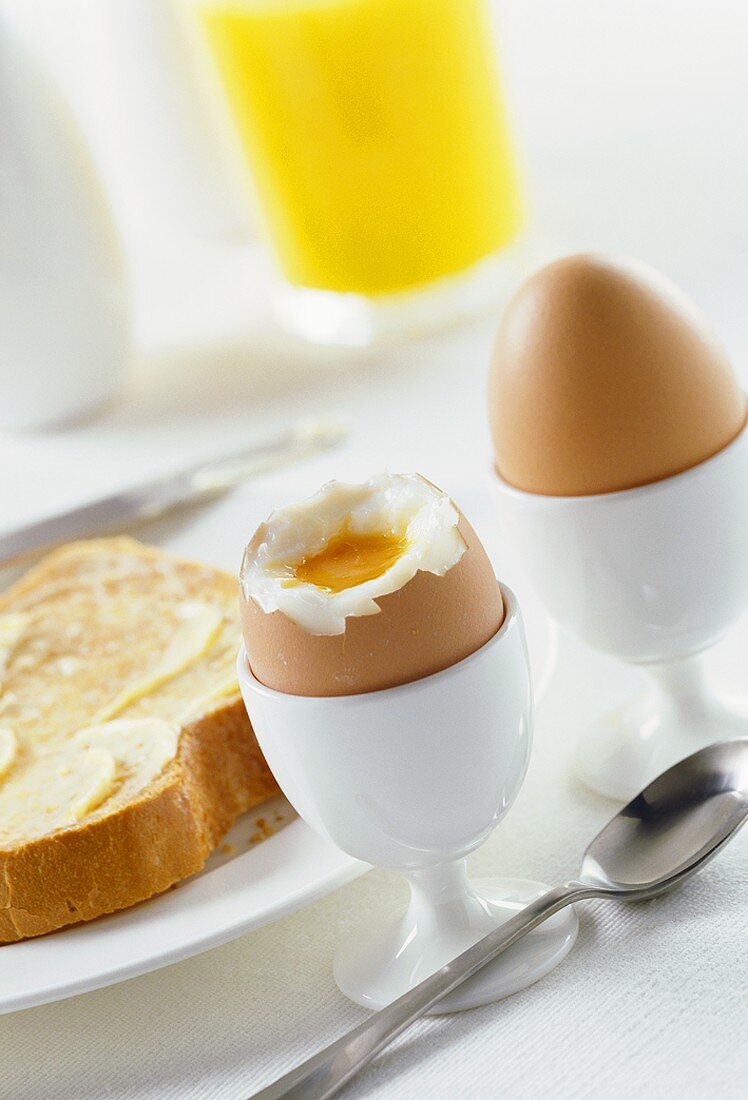 Boiled eggs with & without tops  in egg cups, buttered toast