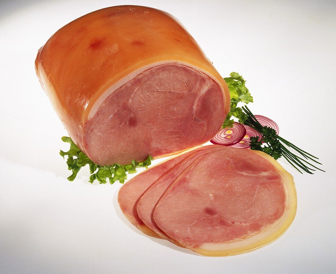 A piece of cooked ham and three slices