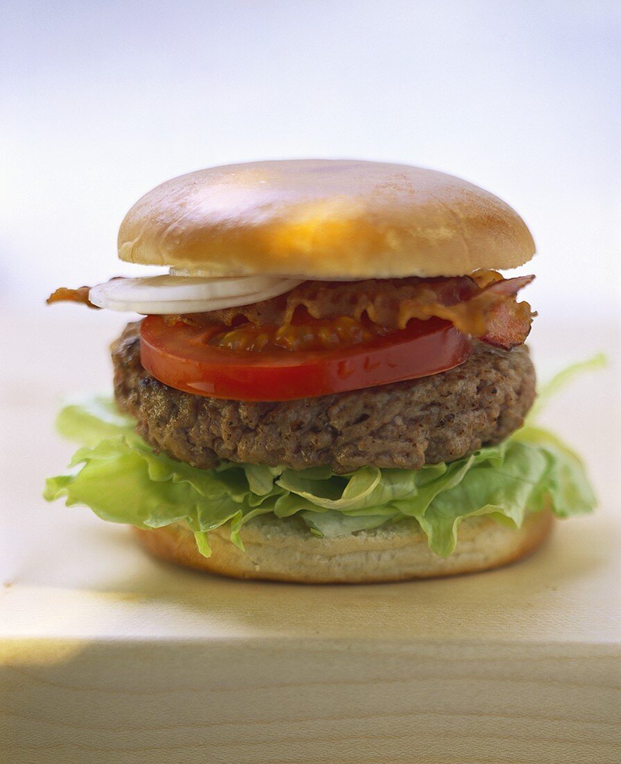 A hamburger with lettuce and bacon