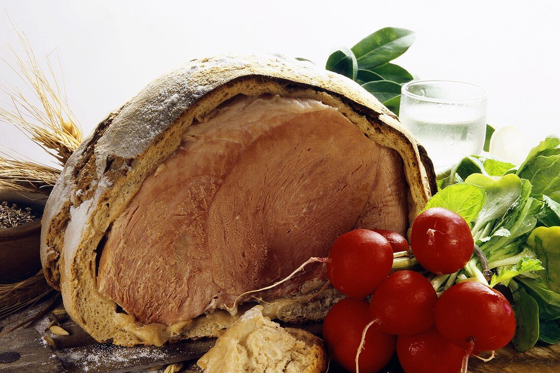 Ham baked in bread dough, a bunch of radishes in front