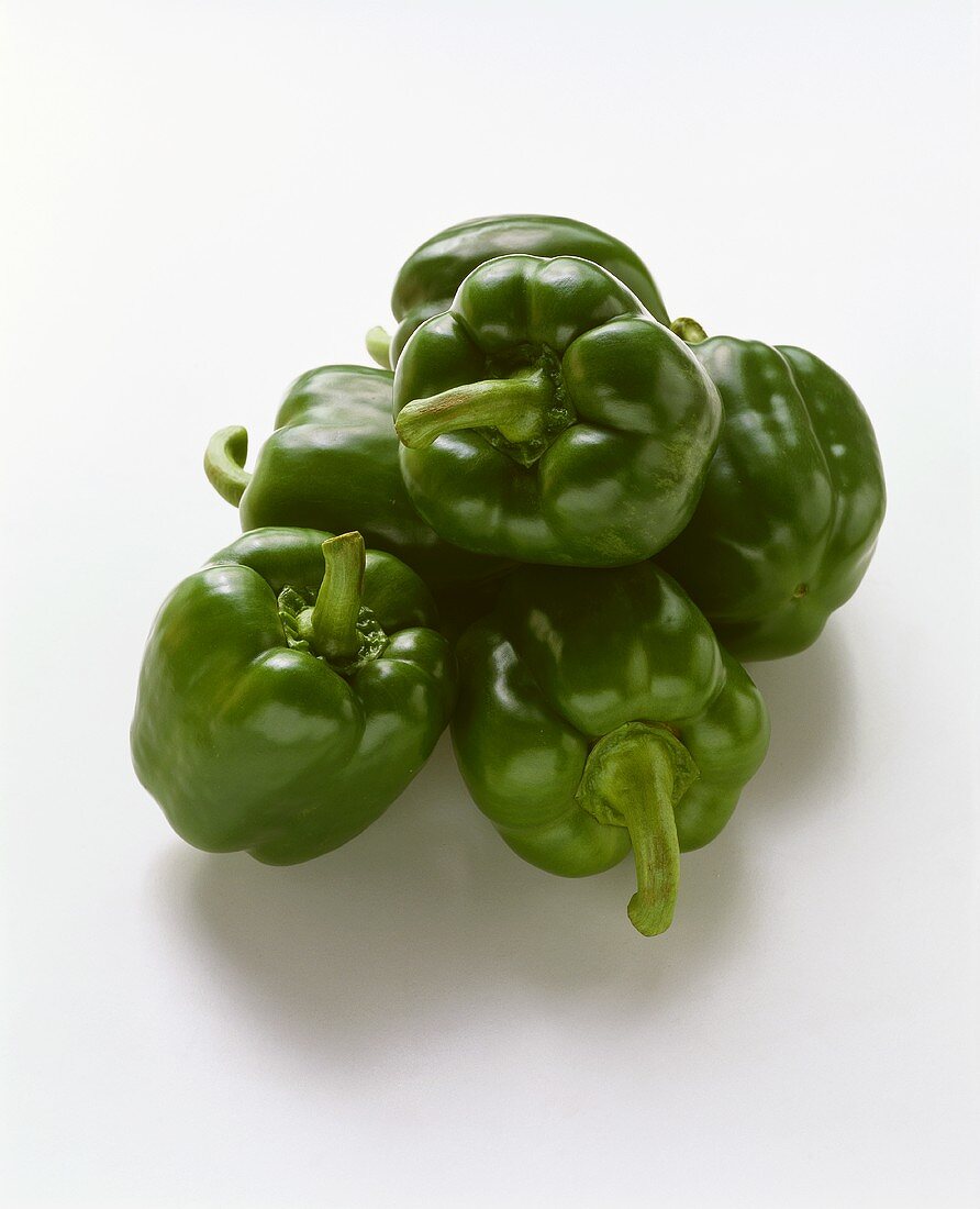 Several green peppers on white background