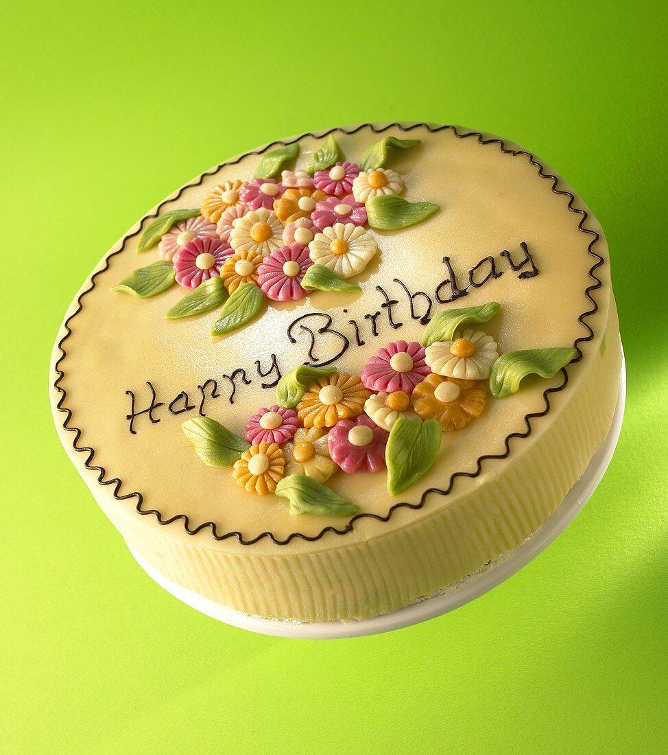 Cake with marzipan flowers and the words 'Happy Birthday'