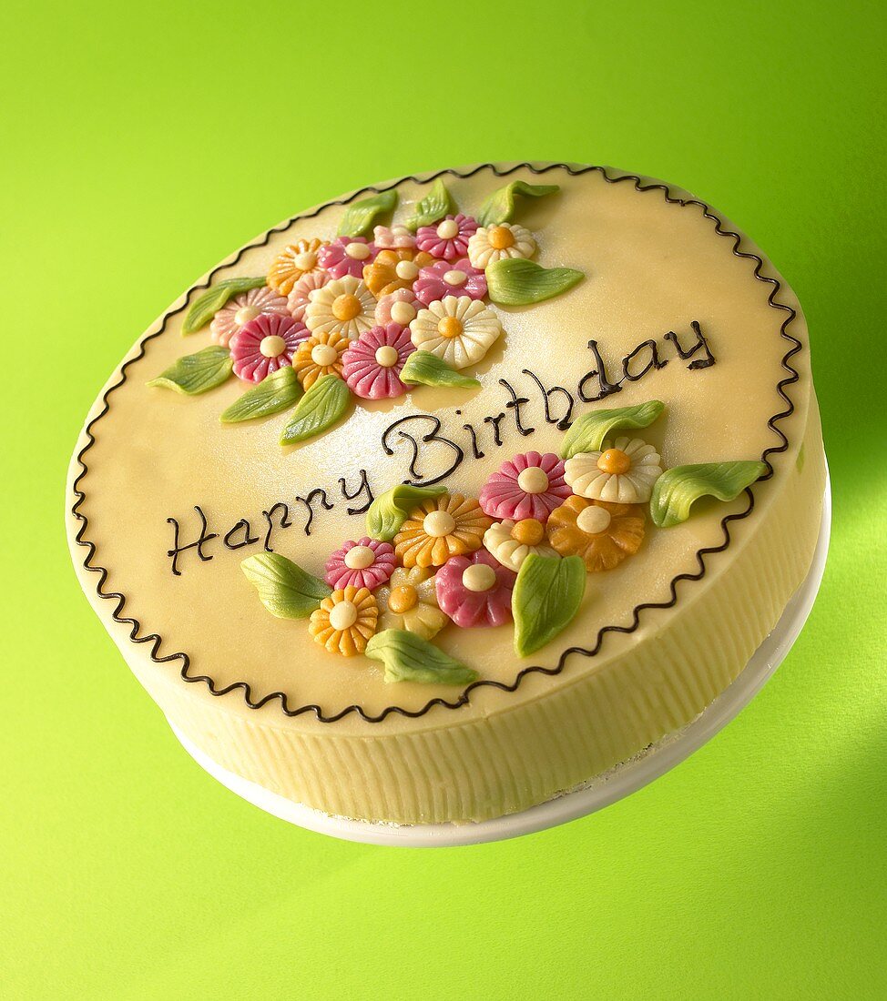 Torte mit Marzipanblumen und Aufschrift 'Happy Birthday'