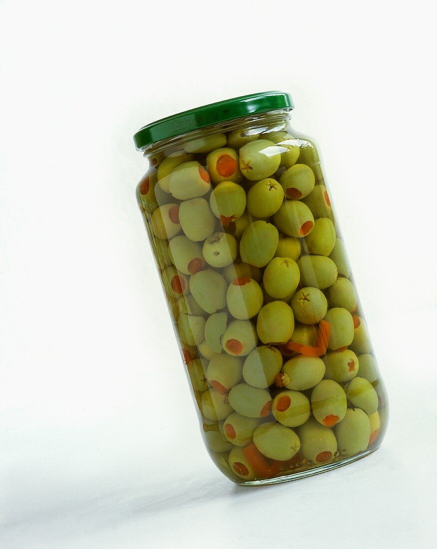 A jar of green olives stuffed with peppers