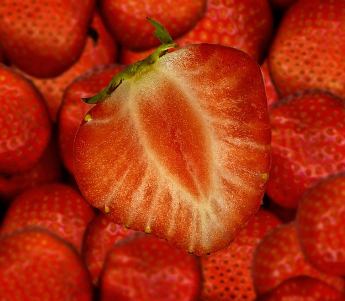 Half a strawberry on whole strawberries