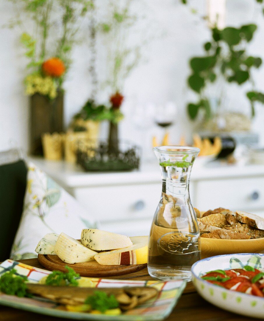 Käse, Fisch, Brot & Tomatensalat auf einem Tisch angerichtet